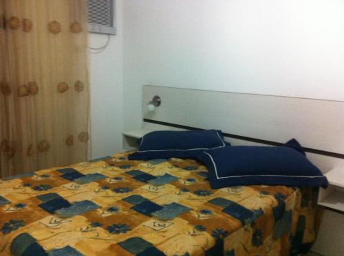邦巴斯EXCELENTE APTO NA QUADRA DA PRAIA的一间卧室配有一张带蓝色枕头的床。