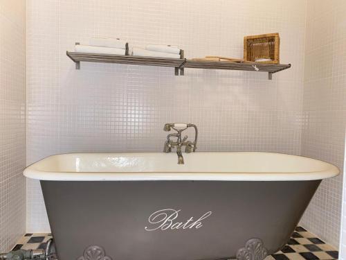布吕门赫特奥德珀斯特坎图酒店的带浴缸的浴室和水槽