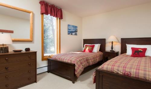 威尔森Tamarack的一间卧室设有两张床和窗户。