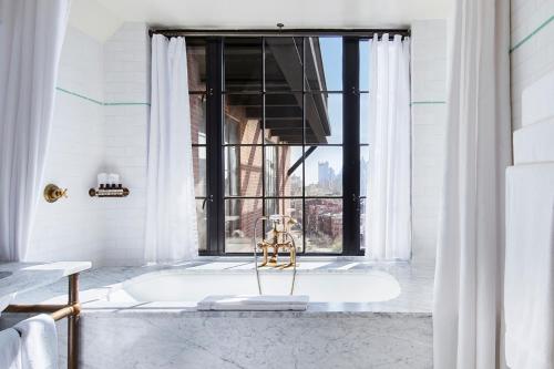 纽约柏威里酒店的白色的浴室设有浴缸和窗户。