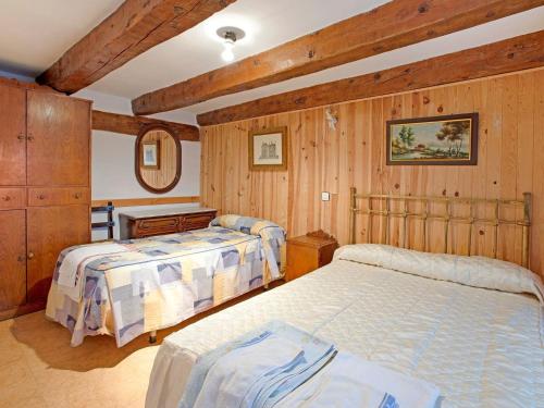 巴利亚多利德Snug Holiday Home in Valladolid with Private Pool的木墙客房的两张床