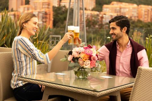 波哥大布赫乌萨昆酒店的坐在桌边喝啤酒的男人和女人