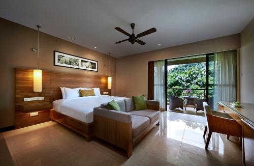 热浪岛塔拉斯海滩Spa度假酒店的一间卧室配有一张床、一张桌子和一张沙发