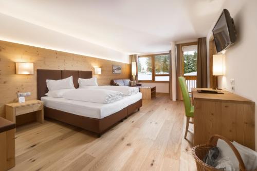阿尔卑斯休斯山弗罗拉皮那运动酒店的酒店客房,配有床和电视