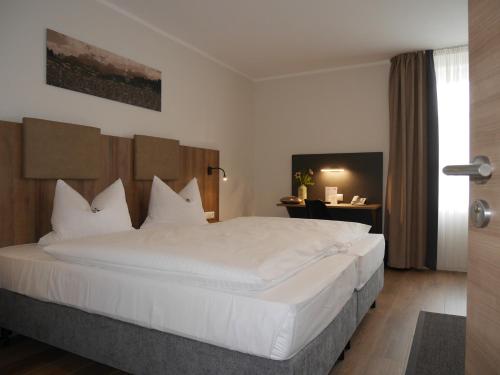 纽法恩安德尔施茨酒店的一间卧室配有一张带白色床单的大床
