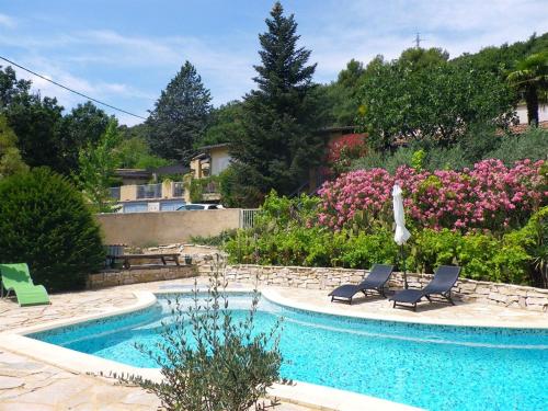 Villeneuve马斯杜卡卓尼尔酒店的花园旁带2把躺椅的游泳池
