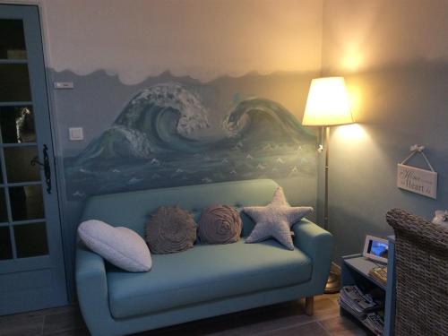 Villeneuve马斯杜卡卓尼尔酒店的一间设有蓝色沙发的客房,墙上挂有绘画作品