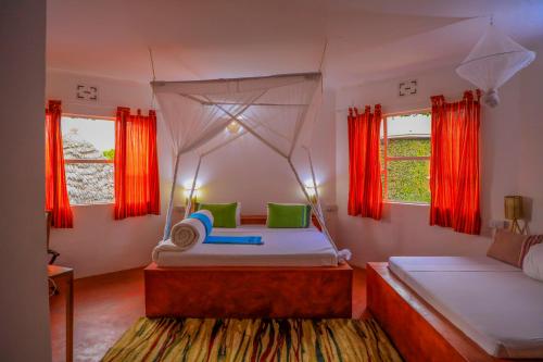 阿鲁沙Dan Stam Hotel的一间卧室设有两张床和红色窗帘