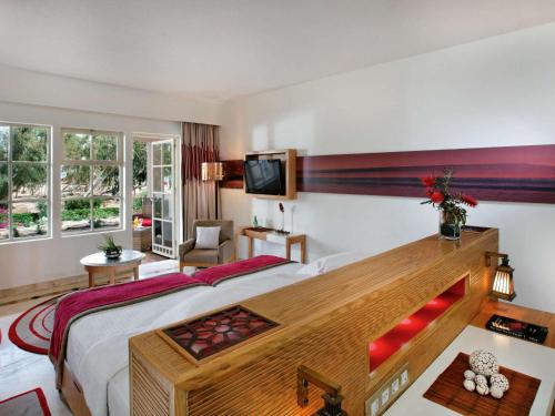 赫尔格达Movenpick Resort & Spa El Gouna的酒店客房设有一张大床和一台电视。