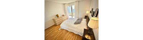 洛桑Close to Unil EPFL, spacious and bright 2 bedrooms的白色的客房设有床和窗户。