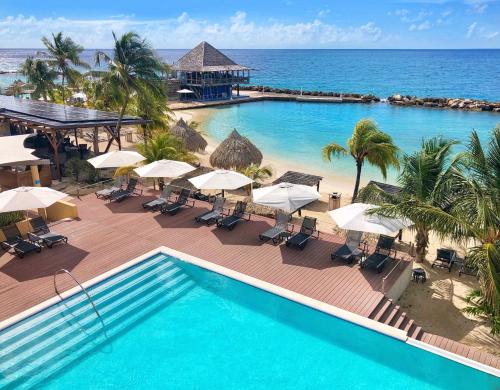威廉斯塔德库拉索阿维拉海滨酒店的享有带遮阳伞的游泳池和大海的顶部景致