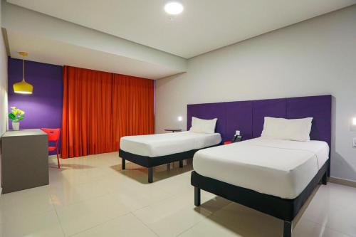 贝伦Rede Andrade Docas的酒店客房设有两张床和红色的墙壁。