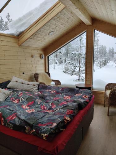 锡尔卡Polar Lights Lodge的一张位于带大窗户的房间内的床铺