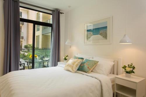 阿克拉Embassy Gardens Luxury Apartments的卧室设有白色的床和大窗户