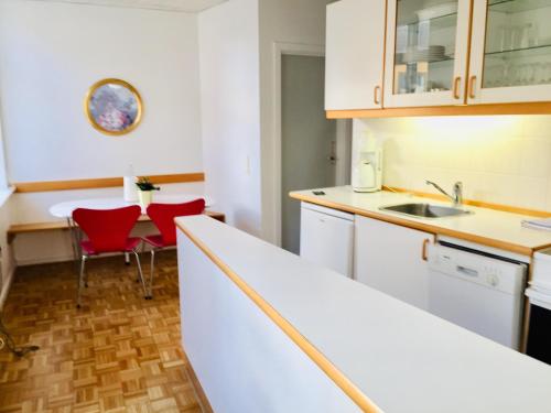 欧登塞City Hotel Apartments的厨房配有白色橱柜和桌椅