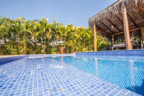 弗洛里亚诺波利斯Pousada Vila Tamarindo Eco Lodge的一座游泳池,其内拥有棕榈树度假村