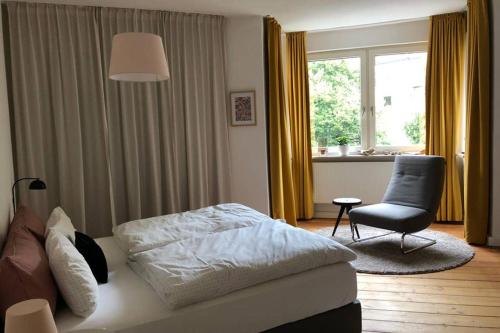 奥格斯堡Charmant Leben im Textilviertel - stilvolle Wohnung - zentral und ruhig的卧室配有床、椅子和窗户。