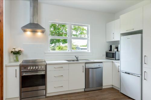 布伦海姆Stylish on Severne的白色的厨房配有水槽和冰箱