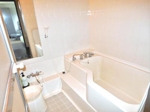 伊东J花园酒店的带浴缸、卫生间和盥洗盆的浴室