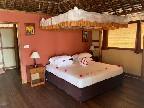 MkwajaBarry's Beach Resort的一间卧室配有一张带天蓬的大床