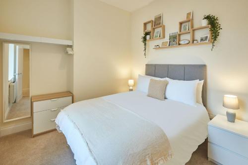 斯卡伯勒Host & Stay - South Cliff Apartment的卧室配有一张白色大床和镜子