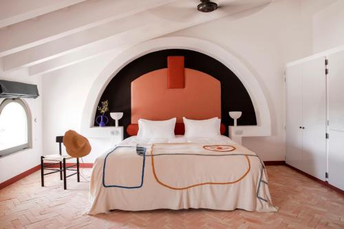 阿莱奥尔Menorca Experimental的一间卧室配有一张大床和红色床头板