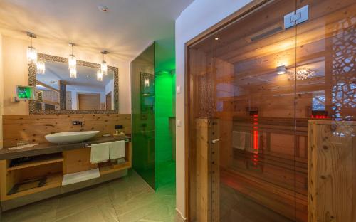 法尔泽斯维何尔翠湖酒店的浴室配有盥洗盆和带镜子的淋浴