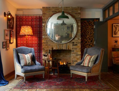 伦敦伦敦艺术家酒店的客厅配有两把椅子和壁炉