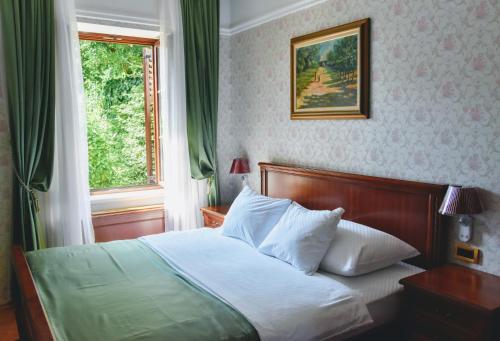 杜布罗夫尼克卡兹别克精品酒店的卧室内的一张床位,卧室设有窗户和一张四柱床