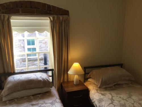 阿马多宾旅馆的一间卧室设有两张床和窗户。
