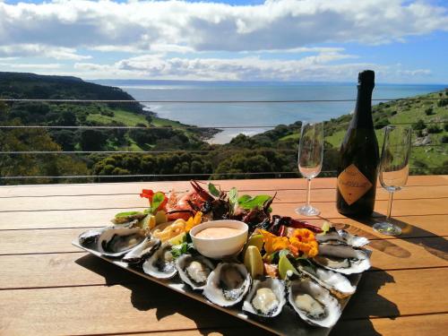 潘尼萧Sea Dragon Kangaroo Island的桌上的牡 ⁇ 盘和一瓶葡萄酒