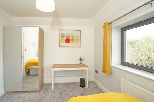 斯劳Home from home - 4 Double Bed House with Parking的一间卧室配有一张床、一张书桌和一个窗户。