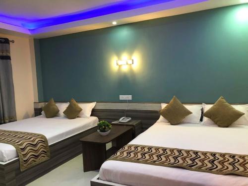 ItahariYara Hotel的酒店客房设有两张床和蓝色的墙壁。