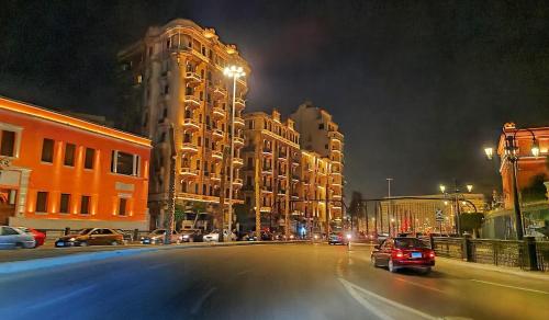 开罗Heritage Hostel Cairo的街道,夜间有汽车和建筑