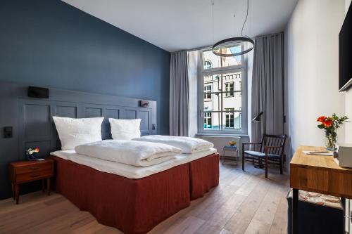 吕贝克Hotel Die Reederin的一间卧室设有一张大床和一个窗户。