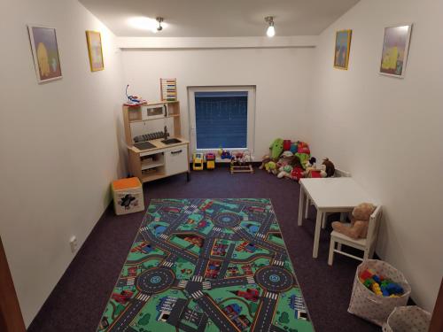 哈拉霍夫Hvězda Apartments的一间儿童间,配有一张桌子和地毯