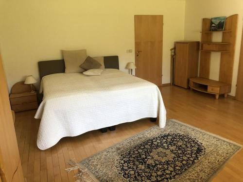 穆尔海姆Secret Garden的卧室配有白色的床和地毯。
