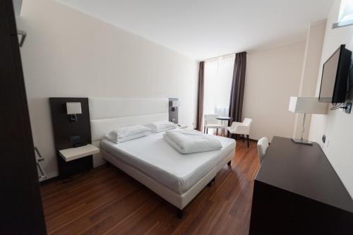 内格拉尔Kona Hotel Verona的一间卧室配有一张床、一张书桌和一个窗户。