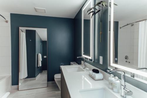 迈阿密Mint House Miami - Downtown的浴室设有两个水槽和蓝色的墙壁。