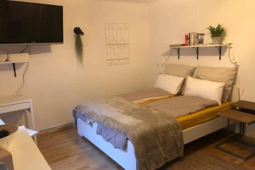 基尔Gemütliche sanierte 1 Zimmer Wohnung mit privatem Parkplatz im Zentrum的客房设有一张床和一台平面电视。