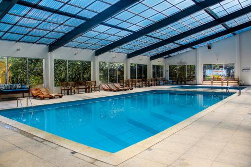波苏斯-迪卡尔达斯Monreale Resort Parque Aquático的一个带玻璃天花板的大型游泳池