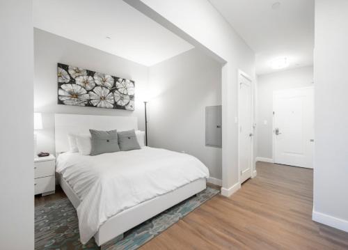 波士顿Global Luxury Suites East Boston的白色的卧室设有白色的床和白色的墙壁