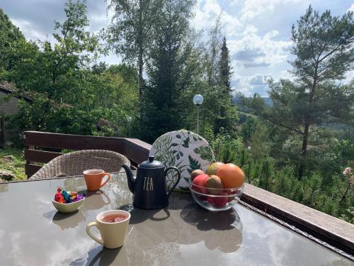 斯塔沃洛Modern Holiday Home in Stavelot with Terrace的一张桌子,上面放着一碗水果和两杯咖啡