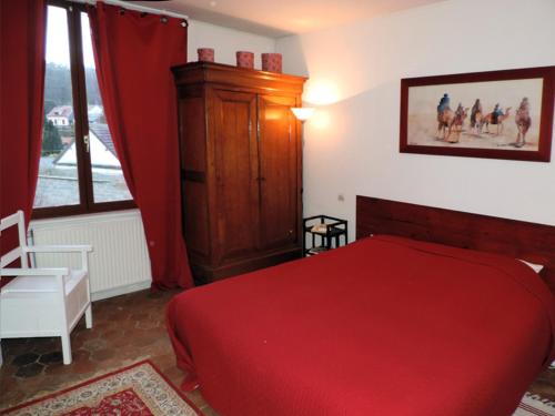 卢维耶路德斯富热尔斯尚布里住宿加早餐旅馆的一间卧室设有红色的床和窗户。