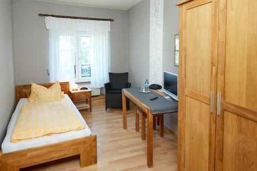 Lutzerath马斯酒店-餐厅的一间卧室配有一张床、一张桌子和一张桌子