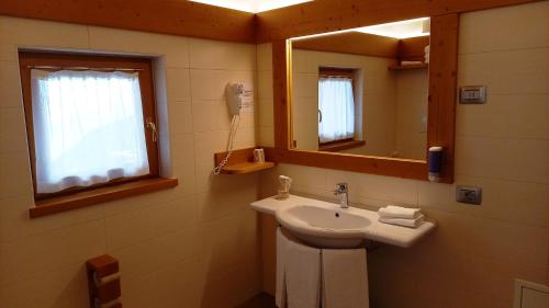 Vaneze邦多纳山脉酒店的一间带水槽和镜子的浴室