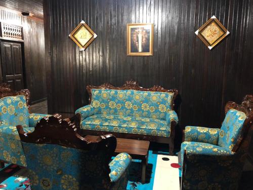庞卡兰布翁Mimi Guest House Syariah Pangkalan bun的客厅配有沙发和两把椅子