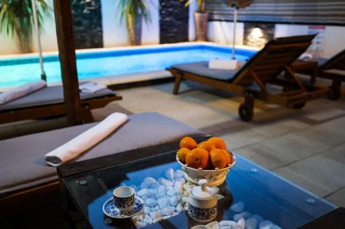 扎达尔Apartment Rustica Zadar with exclusive use of the pool-ground floor的游泳池旁的桌子上放着一碗橘子