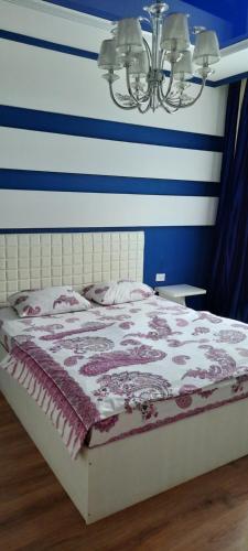 阿克托比SHANYRAK Гостевой дом的蓝色和白色条纹间的一张床位