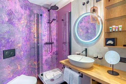 Struppen-SiedlungHotel Bei Gretel, Wellness & Ayurveda的紫色浴室设有水槽和淋浴